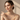 Woman wearing the Kyoto Pearl freshwater pearl necklace, bracelet and earrings set, against a beige background.